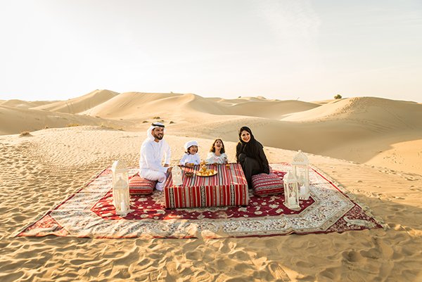 Arabian family with kids having fun in the desert - Parents and children celebrating holiday in the Dubai desrt