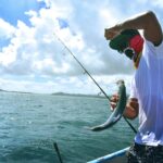 Angler holding a fish on a boat