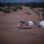 Desert camp with tents and a campfire