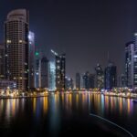 Dubai Marina towers lit up at night over the water