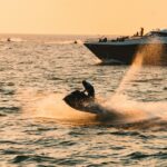 Jet ski at sunset with a boat behind